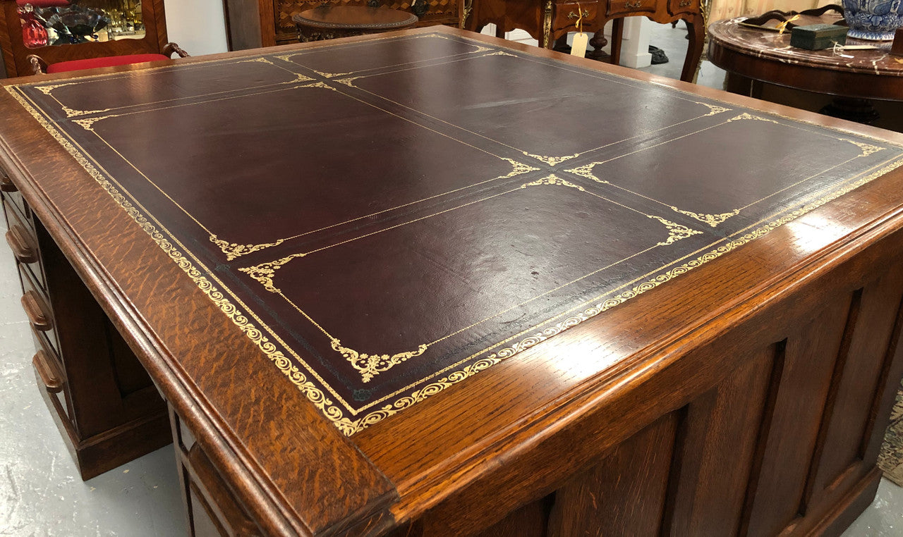 Lovely large English oak partners desk, with a beautiful burgundy tooled leather top. Plenty of storage space, both sides have 9 functioning drawers. It is in very good condition.
