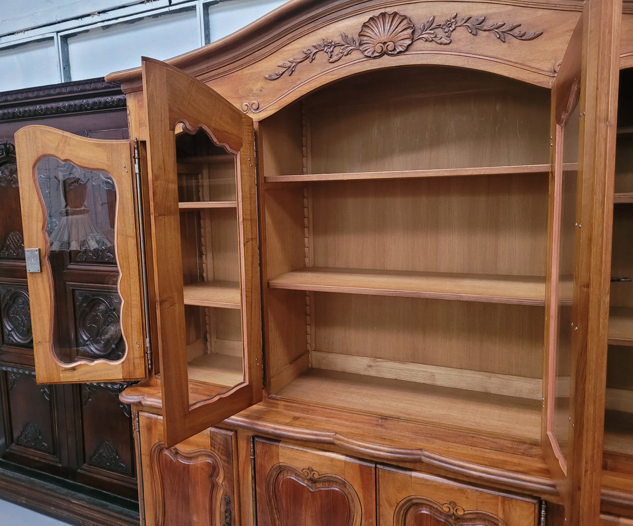 Magnificent French Walnut two-body four door display cabinet. Heaps of storage space with four glass doors at the top with shelves and four solid doors below also with shelving. It has been sourced from France and comes with a key for each door and all are lockable. In good original detailed condition.