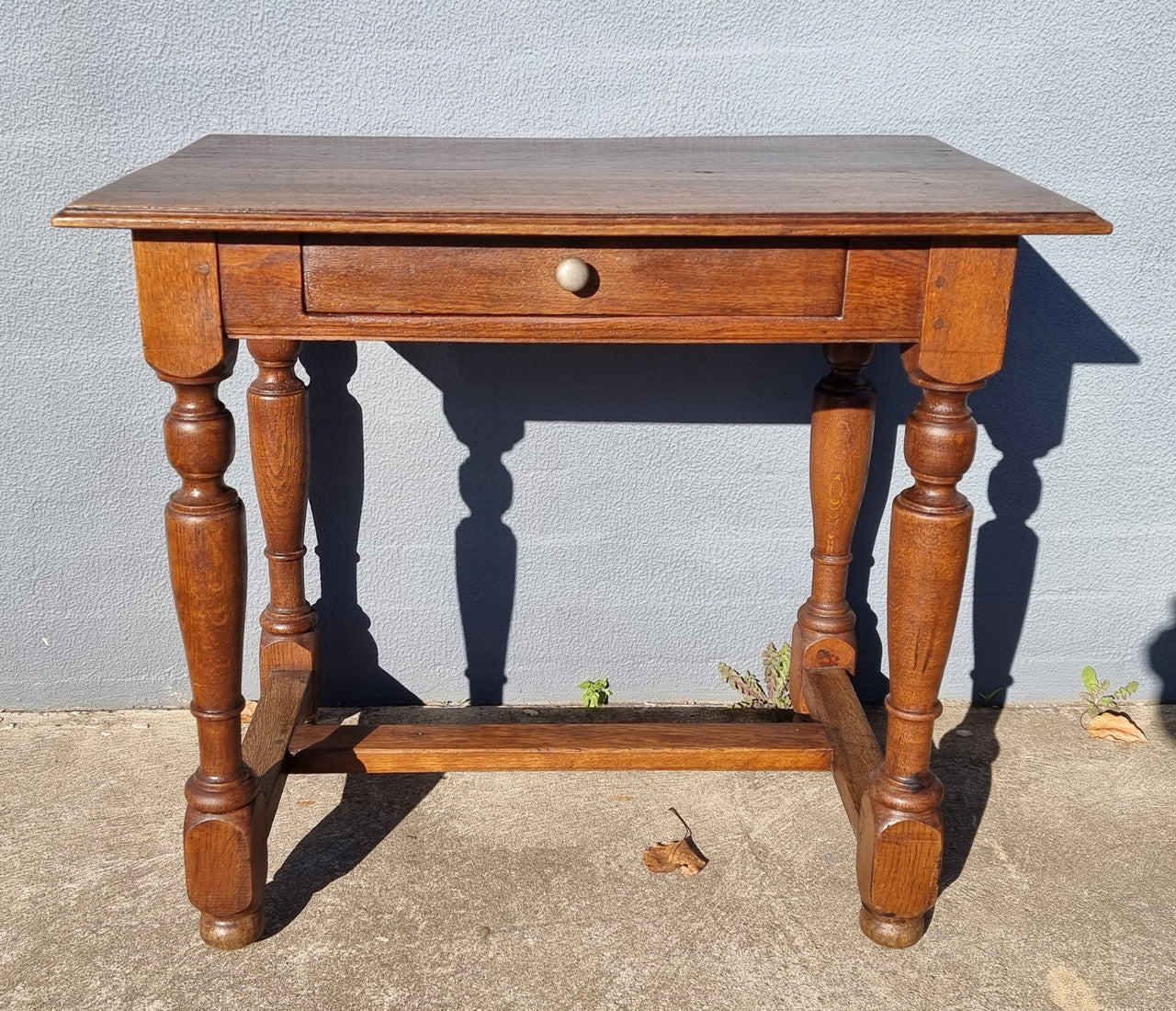 Rustic French Oak side table or desk with single drawer and turned legs. In good original detailed condition.
