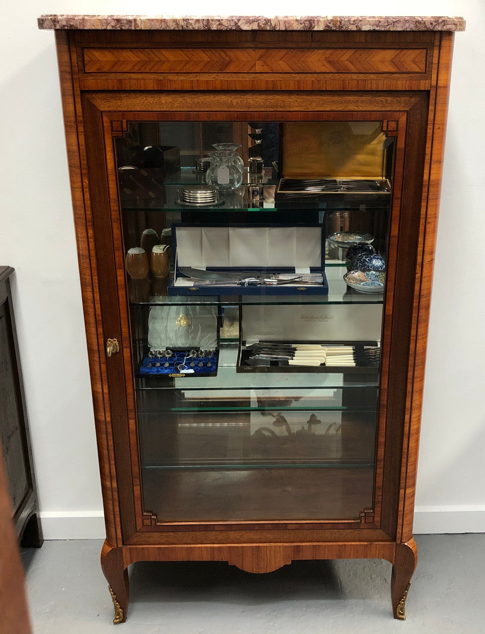 Beautiful French walnut and parquetry inlaid vitrine with lovely bevelled glass and a marble top. It comes with four glass shelves which are adjustable and it is in good original condition.