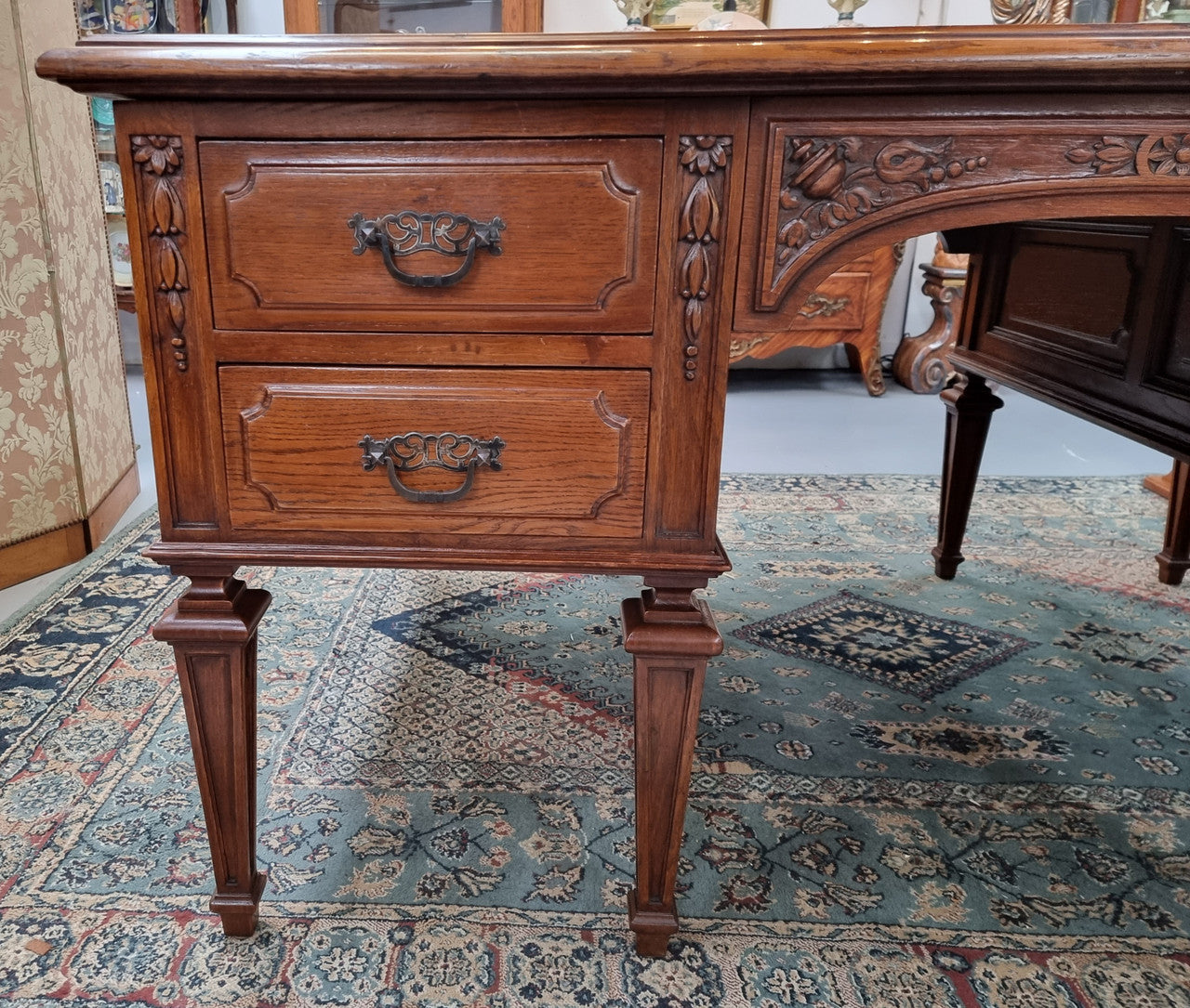Substantial French Louis XVI style Oak partners desk. It has a beautiful leather top, two drawers on either side and decorative carvings throughout. Sourced from France and in good original detailed condition.