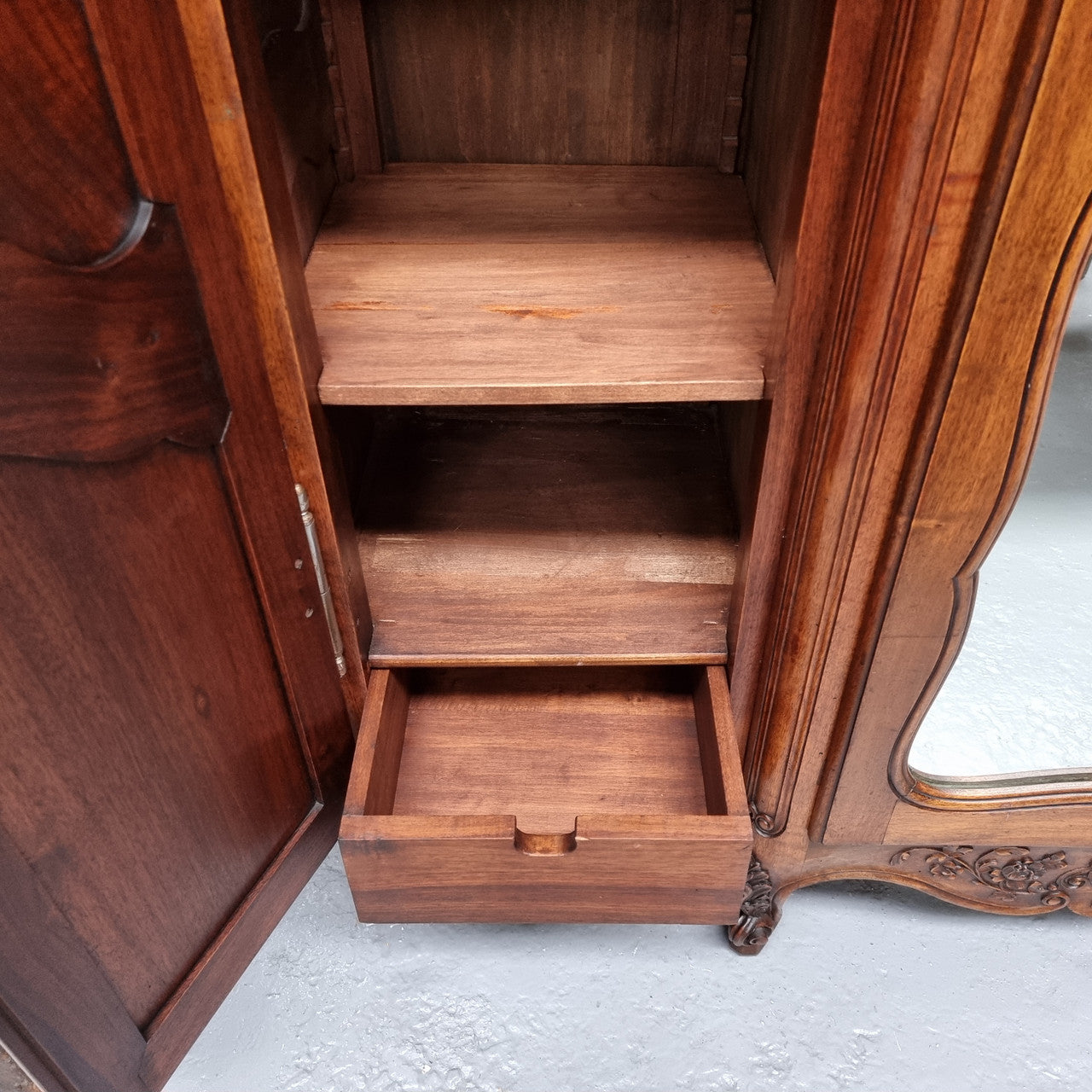 French Walnut Louis XV style three door armoire with 10 fully adjustable shelves in total spread over three sections, two drawers and a mirrored middle door. It has been sourced from France and in good original detailed condition.