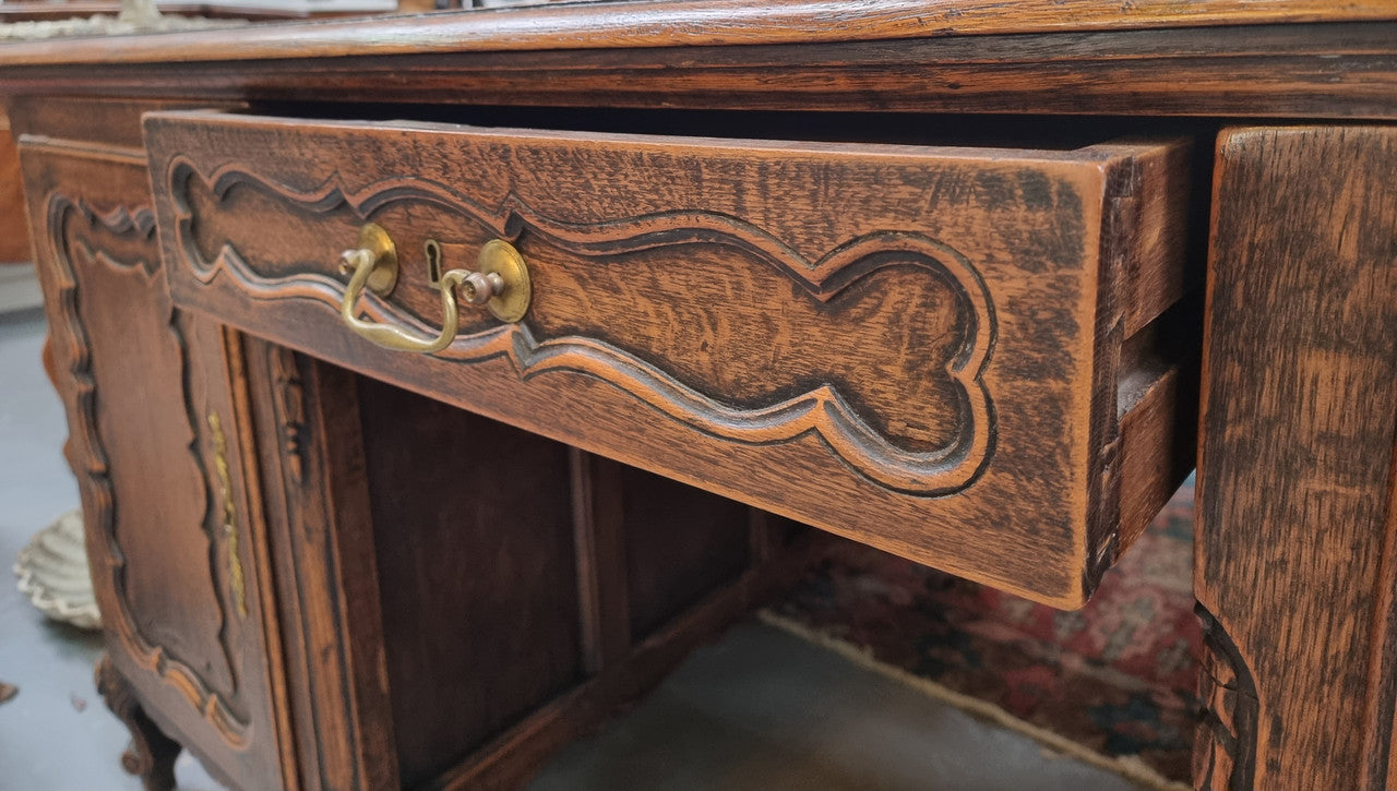 Fabulous Louis XV style French Oak beautifully carved full partners desk with an amazing tooled leather top. Both sides have a functioning drawer in the middle and two cupboards either side. On both sides one cupboard door opens up to four smaller internal drawers. Plenty of storage space and a large top surface to work on. It is in good original detailed condition.