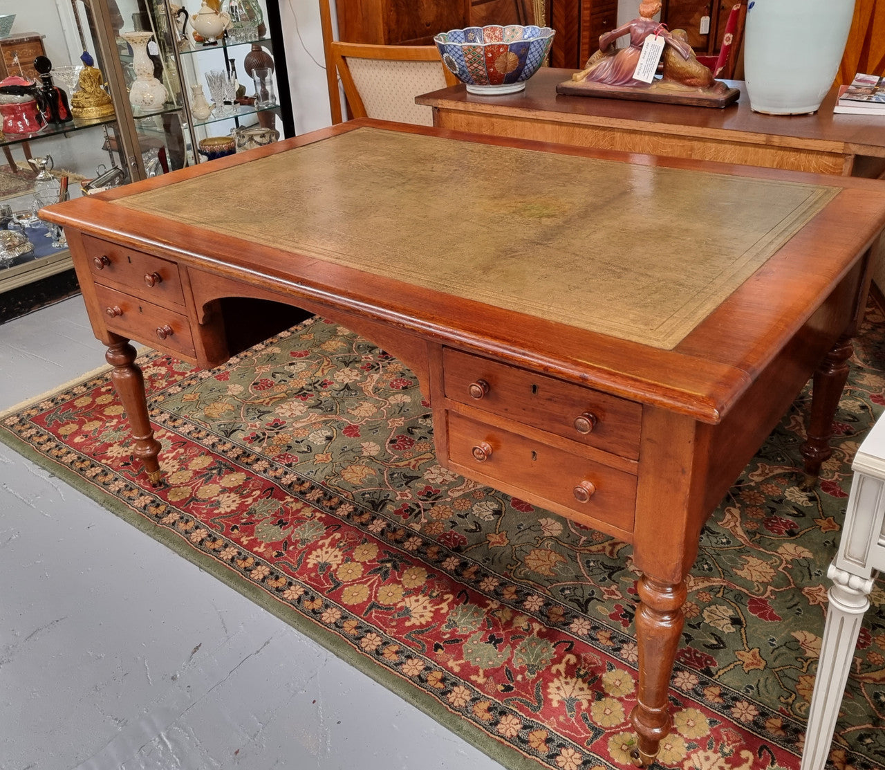 English Cedar full partners desk with attractive tooled leather top, four drawers either side and on caster wheels. In good original detailed condition.