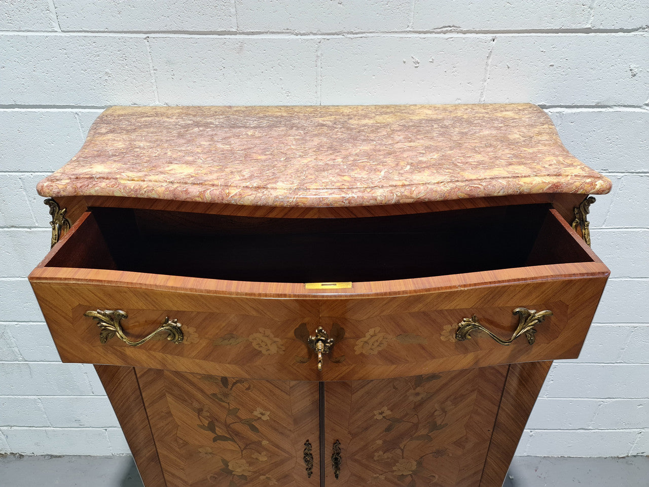French Louis XV style marquetry inlaid marble top side cabinet. It has one drawer at the top and two doors open up to two adjustable shelves. It has beautiful coloured marble and decorative mounts. In good original detailed condition.