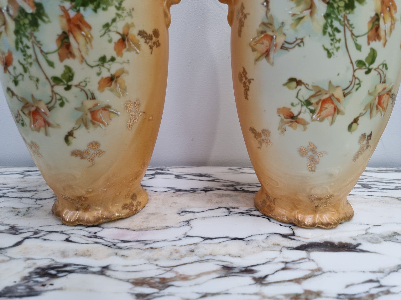 Decorative Pair of Art Nouveau Vases decorated with hand finished roses in muted tones. Gilt highlights. Impressed numbers to base. In good original condition, please view photos as they help form part of the description.