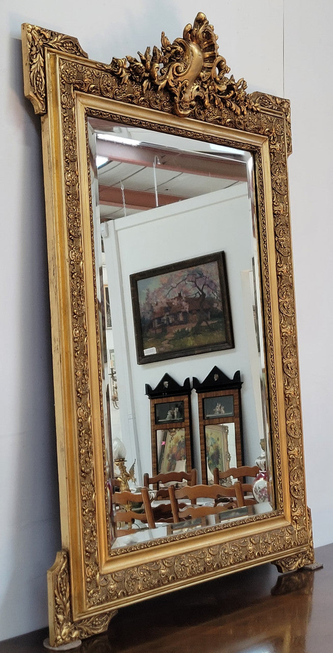 French 19th Century gilt over mantle mirror with beveled glass. In good original detailed condition.