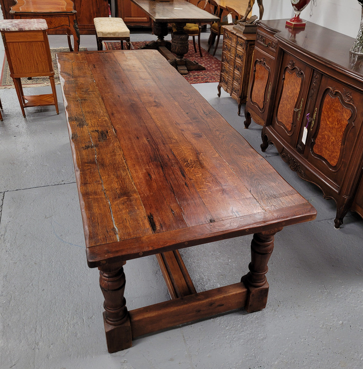 Charming solid rustic Oak stretcher base Farmhouse table. The table is circa 1950's and was custom made using reclaimed oak. It comfortable sits eight and could seat 10. It is in good original detailed condition.