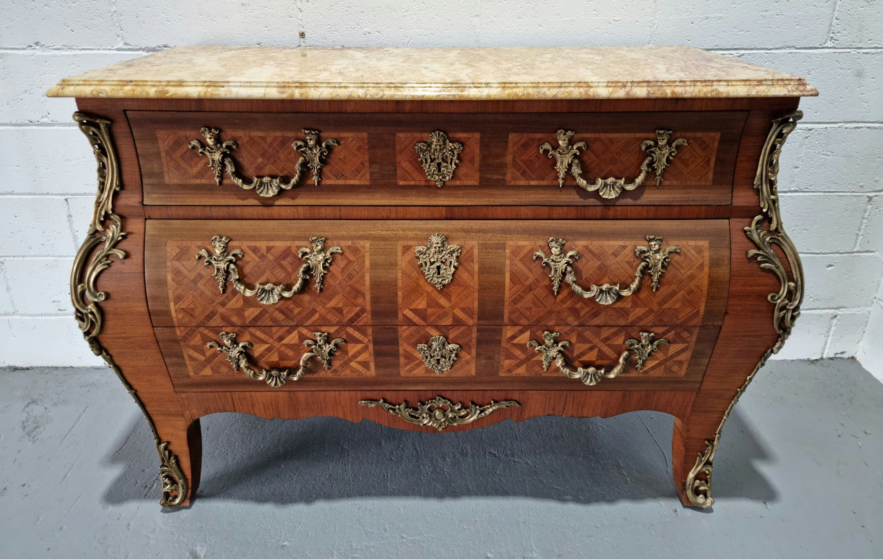 A beautifully inlaid parquetry three drawer commode with a lovely marble top, and decorative ormolu mounts. In good original detailed condition. Circa 1930