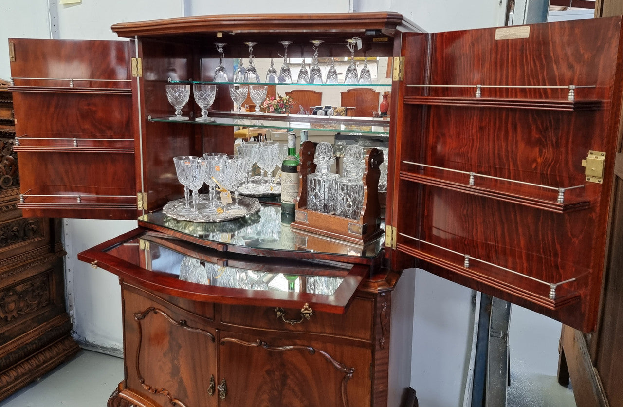 1950’s Chippendale Style Flame Mahogany Four door Bar. The top section has glass shelves and a mirrored pull out tray for storing glasses, decanters & serving etc. It also has a silver presentation plaque to the Mayor of Hawthorn 1958. The bottom section is for storage bottles etc. A stunning and practical piece.