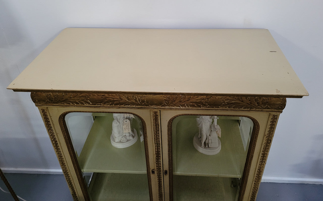 19th Century painted and gilt two door vitrine. Has one adjustable shelf and two drawers. In good original detailed condition.