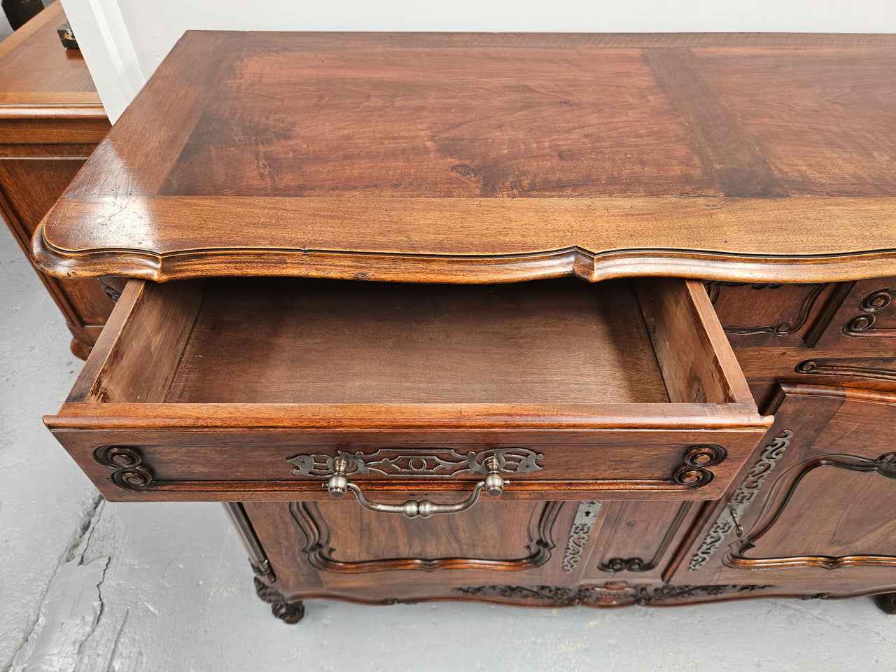 Attractive French Walnut Louis XV style two door two drawer sideboard featuring beautiful carving. Circa: 1930's. It has been sourced from France and it is in good original detailed condition.