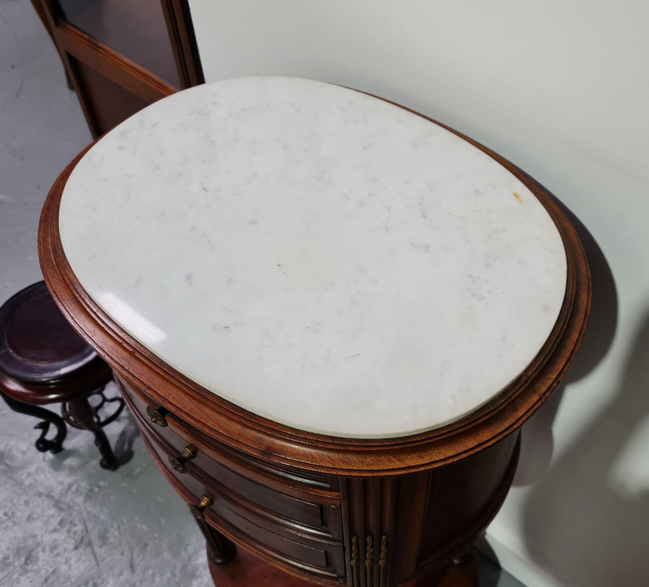 Round Louis XVI style Mahogany marble top side table. It has one drawer and a cupboard for storage. It is in good original detailed condition.