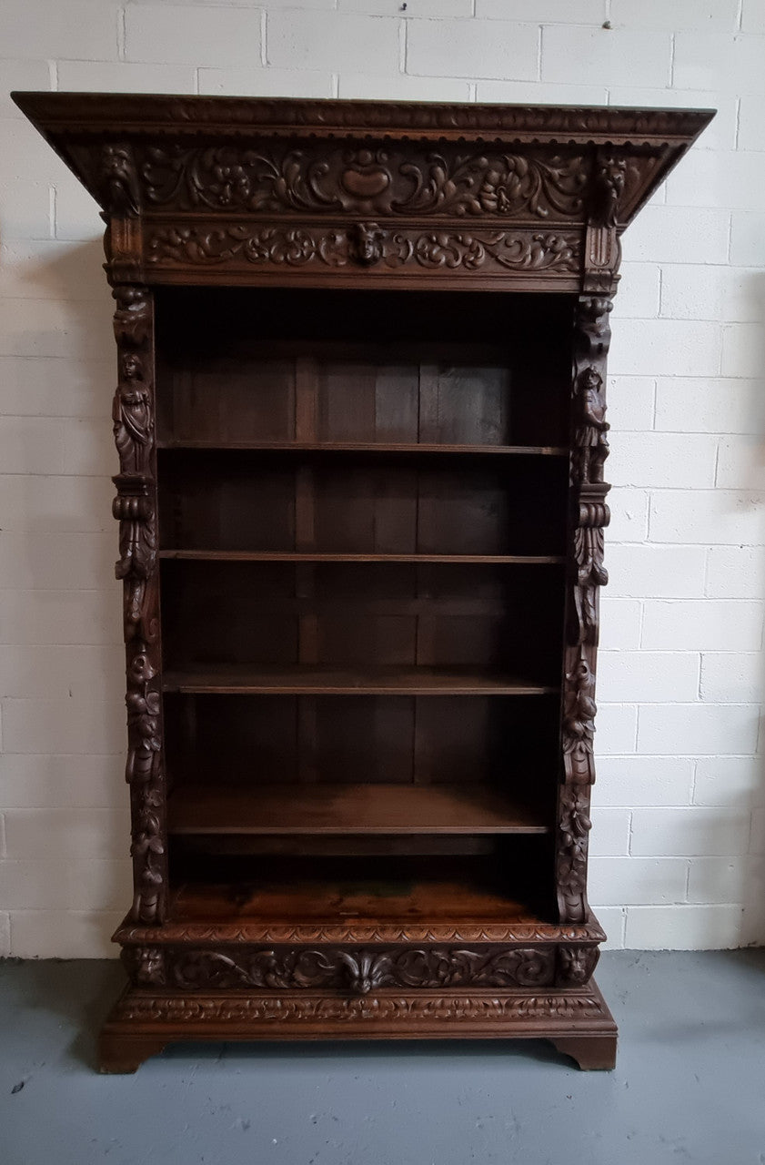 Amazing dark Oak heavily carved Gothic style bookcase with lovely details and adjustable shelves in good original detailed condition. The doors currently have no glass which can easily be added or be left with open shelves.