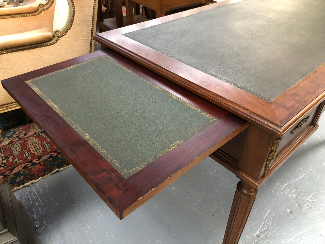 Lovely French Mahogany Louis XVI style leather top desk. With beautiful ormolu details and three drawers. There are also two slides on either side with tooled leather tops and in good original detailed condition.