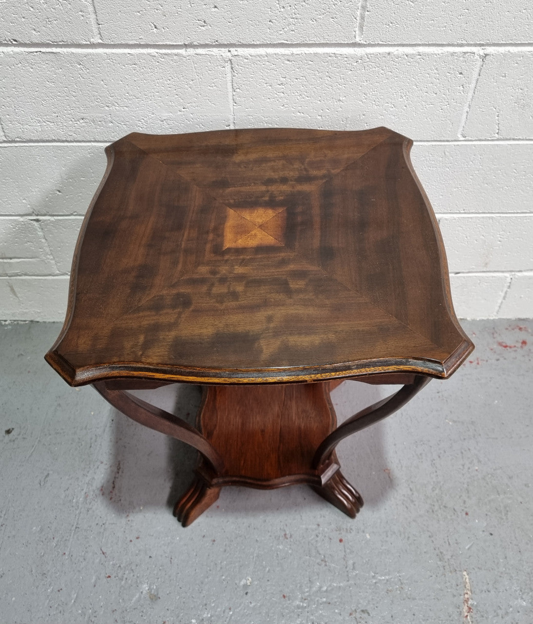 Charming Art Deco Square coffee table. Patterned veneer Top with legs shaping into a lower shelf. In good detailed condition.