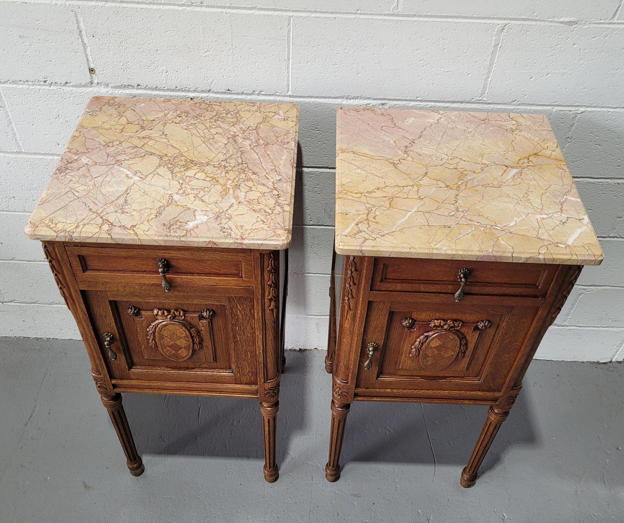 Pair of Louis XV French Oak and marble top bedside cabinets. They have beautiful detailed carving and stunning color marble top. They are in very good original detailed condition.