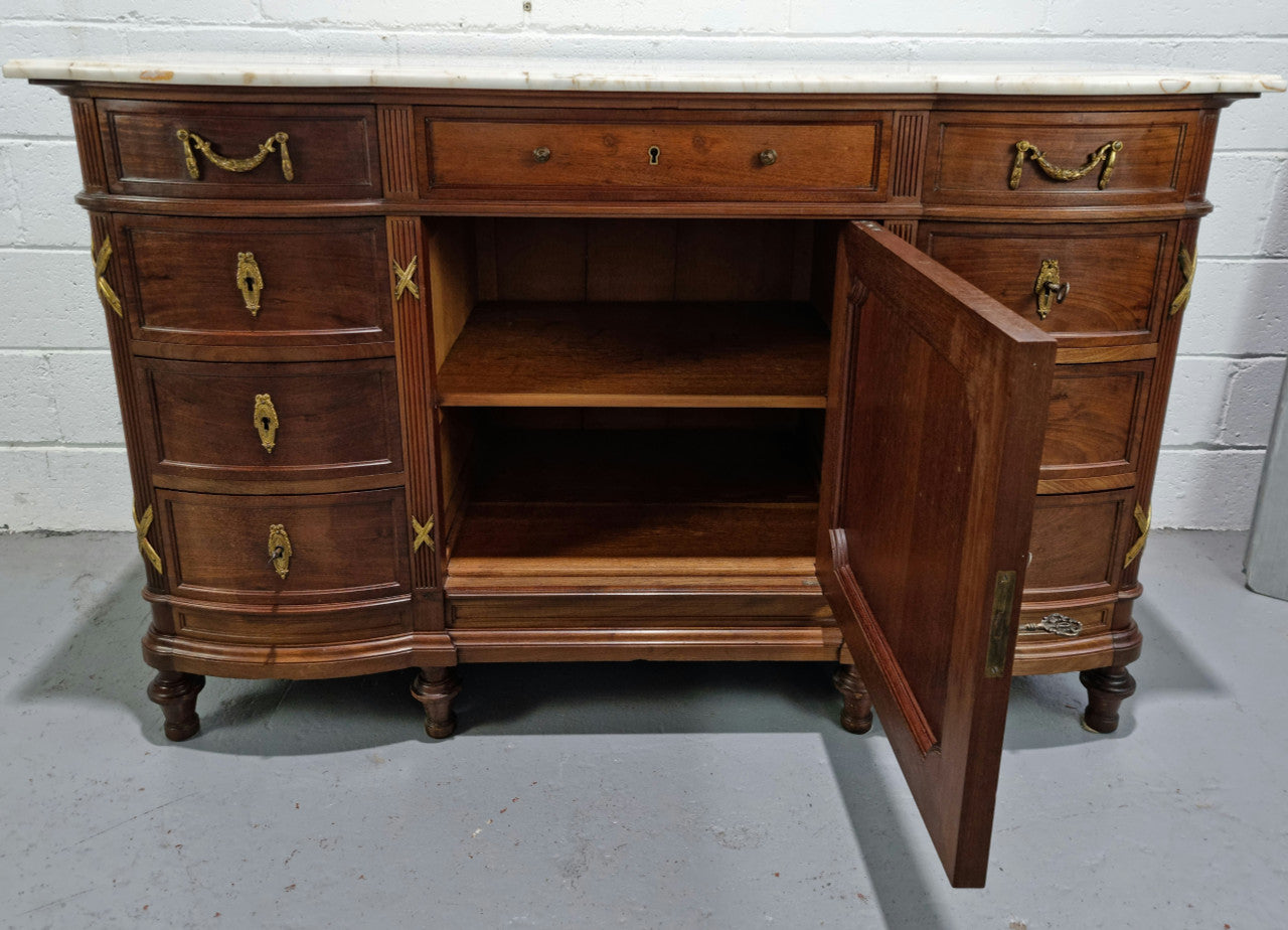 Fabulous French Walnut Louis XVI style cupboard, with a lovely marble top and nine drawers. There is also a cupboard and beautiful ormolu mounts. It is in good original detailed condition.