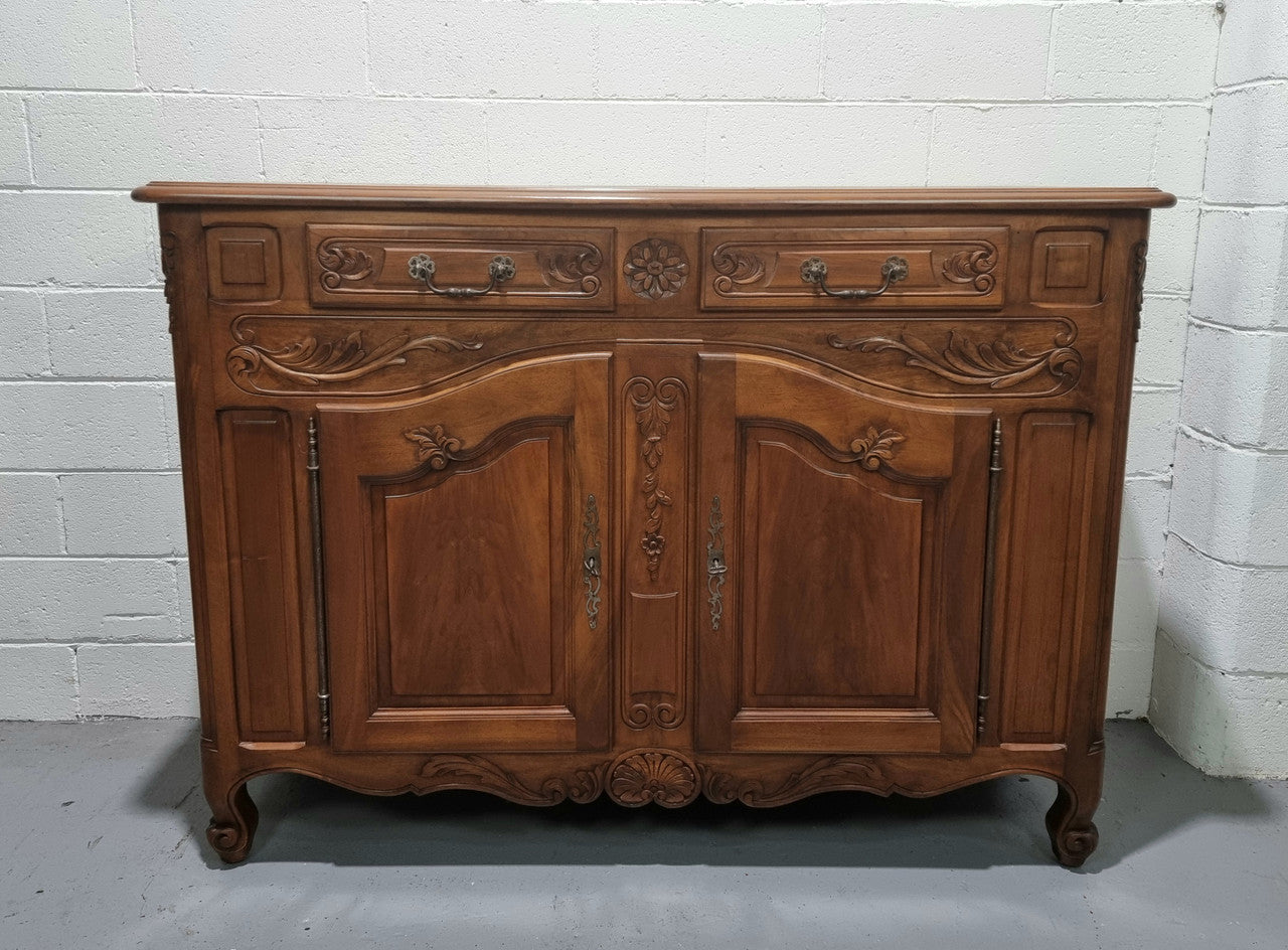 French Walnut two door buffet with parquetry top. It has two drawers and an adjustable shelf. In good original detailed condition and it has been sourced from France.