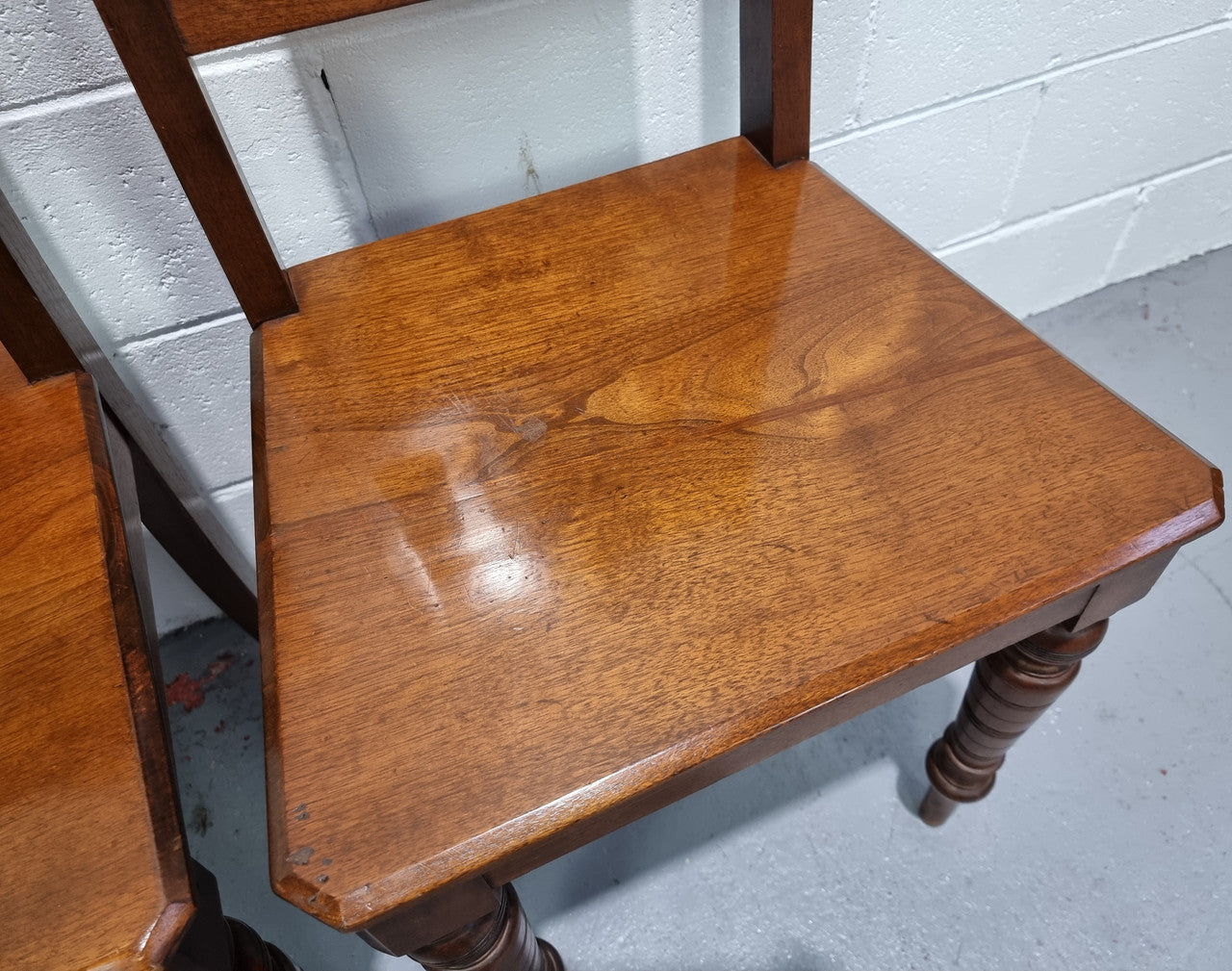 Pair of Edwardian Mahogany hall chairs with original tile in back. They are in very good original detailed condition.