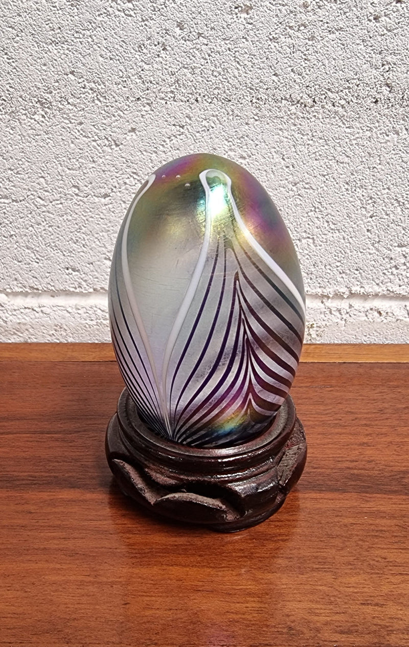 Iridescent glass egg shaped paper weight, on small wooden chinese stand. In good original condition. Please see photos as they form part of the description.