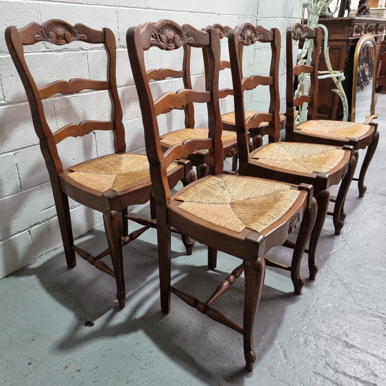 Lovely set of six French oak rush seated provincial dining chairs. They have been sourced from France and are in good detailed condition.