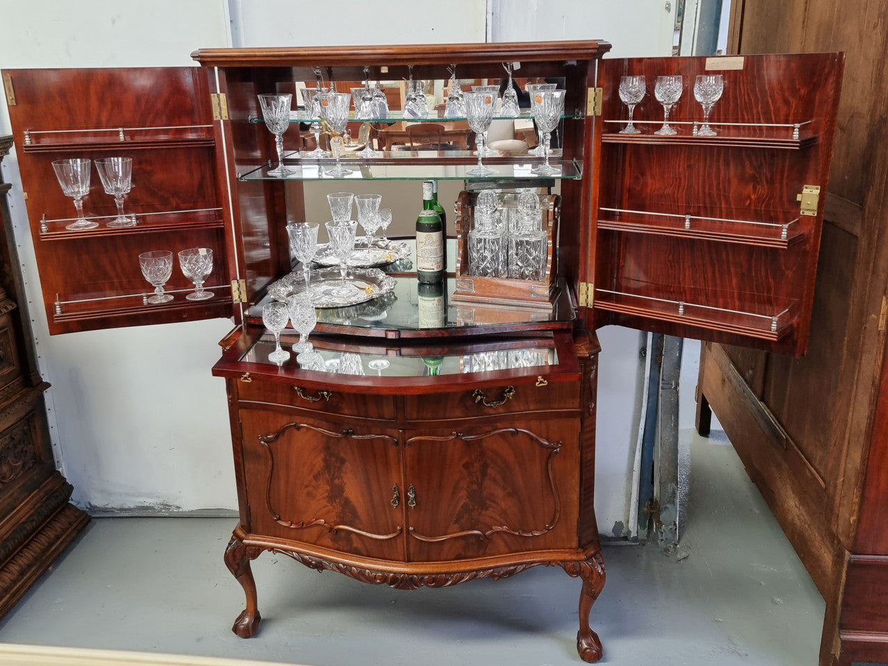 1950’s Chippendale Style Flame Mahogany Four door Bar. The top section has glass shelves and a mirrored pull out tray for storing glasses, decanters & serving etc. It also has a silver presentation plaque to the Mayor of Hawthorn 1958. The bottom section is for storage bottles etc. A stunning and practical piece.