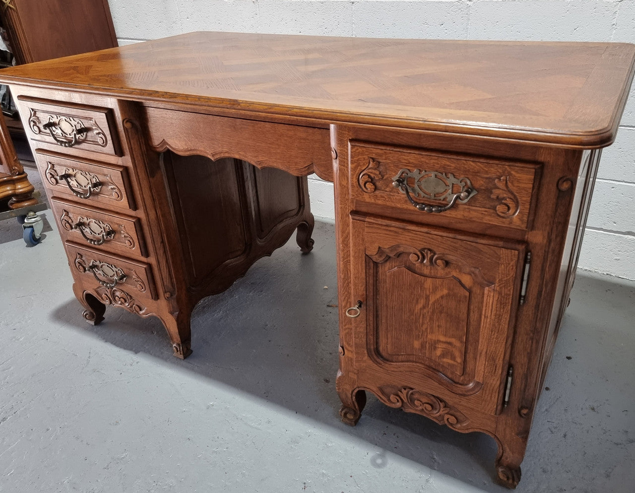 Beautifully carved french oak, faux partners desk with a lovely parquetry top and 6 drawers and 1 cupboard . In good original condition.