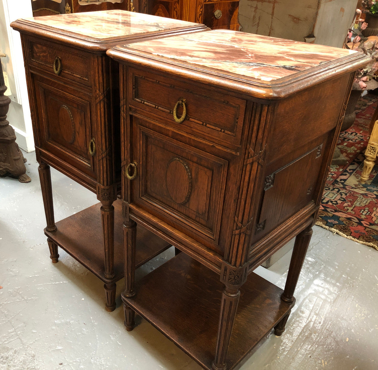 Lovely pair of French Oak Louis XVI style bedside cabinets with inset marble tops a drawer and a cupboard for storage. In good original detailed condition.