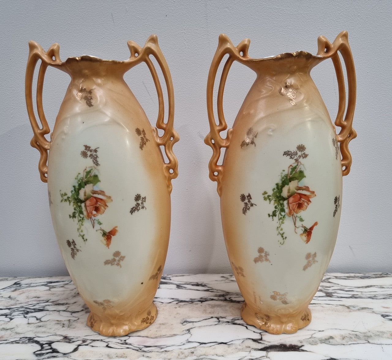 Decorative Pair of Art Nouveau Vases decorated with hand finished roses in muted tones. Gilt highlights. Impressed numbers to base. In good original condition, please view photos as they help form part of the description.