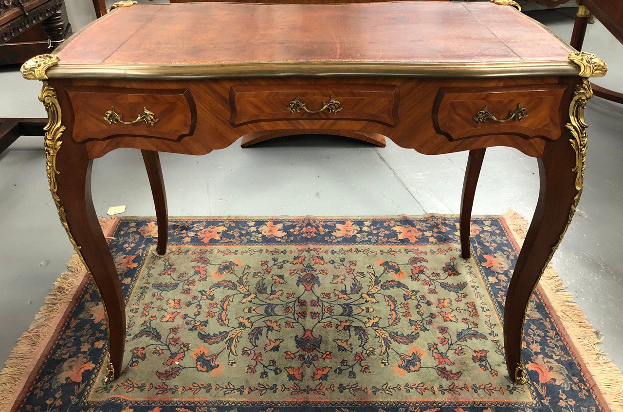 An impressive French Walnut petite Bureau Plat with superb ormolu mounts, original tooled leather top with loads of character and drawers for storage. It is in very good original detailed condition.