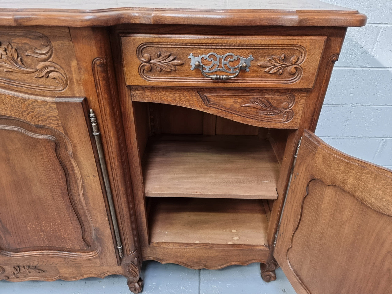 Parquetry top French oak Louis XV style sideboard with two draws and four cupboards. In good original detailed condition.