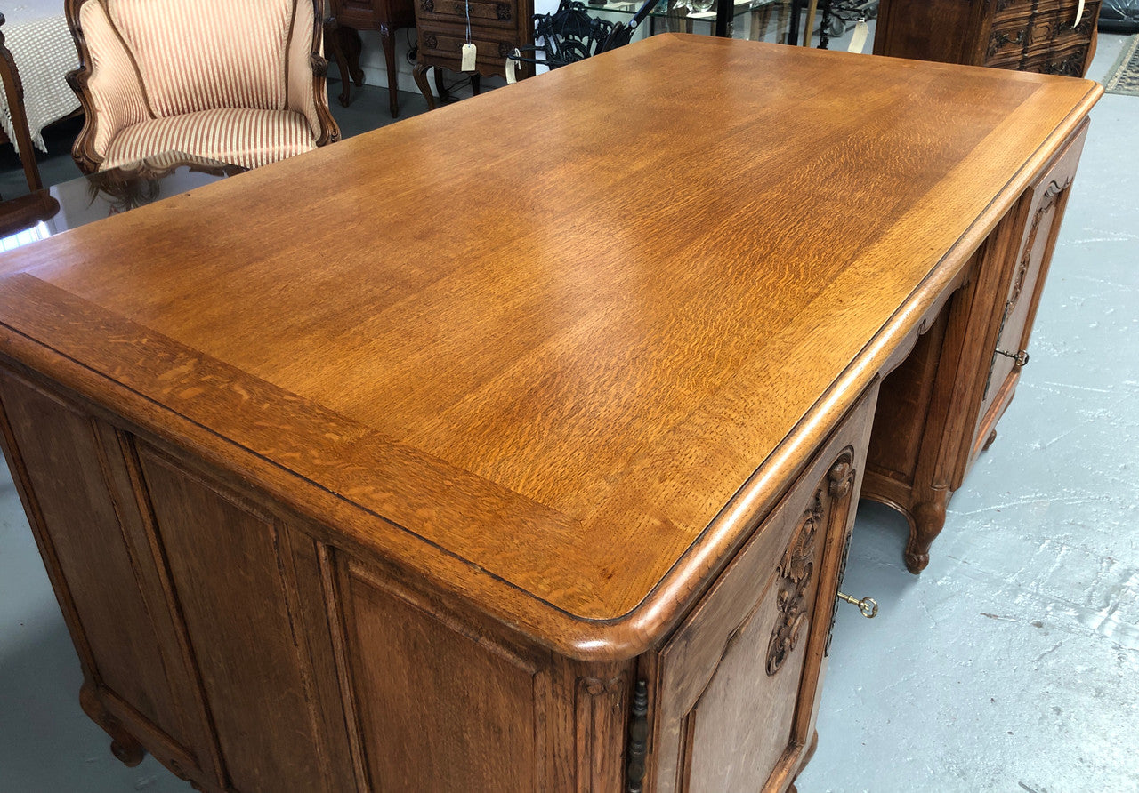 Lovely French oak carved partners desk with one drawer and two cupboards on each side for all your storage needs. in good original detailed condition.