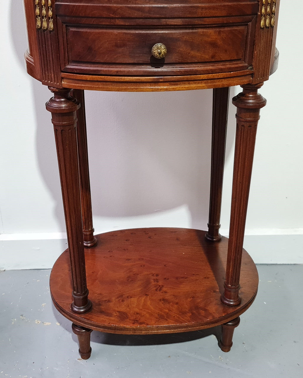 Round Louis XVI style Mahogany marble top side table. It has one drawer and a cupboard for storage. It is in good original detailed condition.