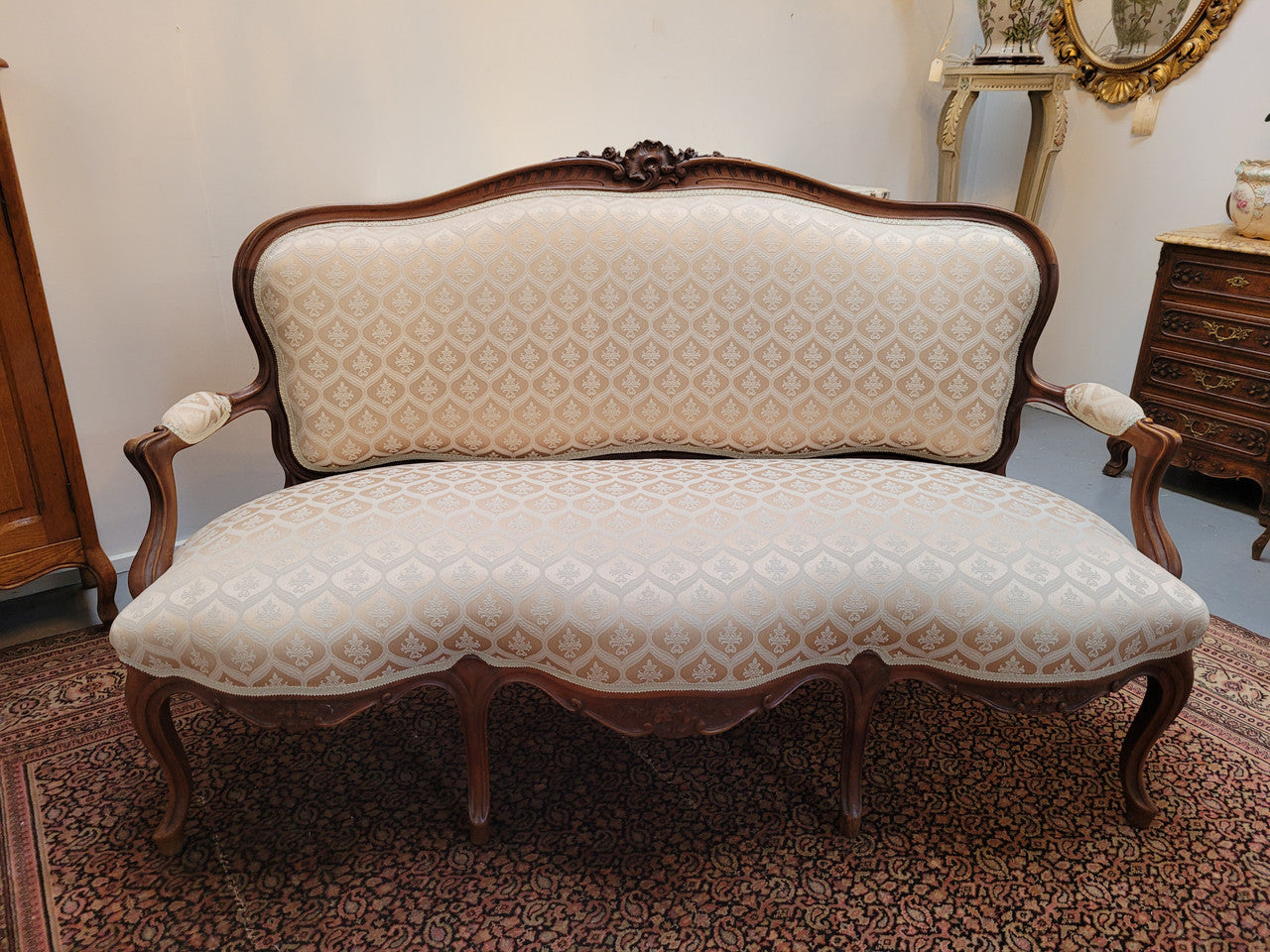 A late 19th Century French Walnut Louis XV style settee with a serpentine front. This settee upholstery is like new and is in very good condition.