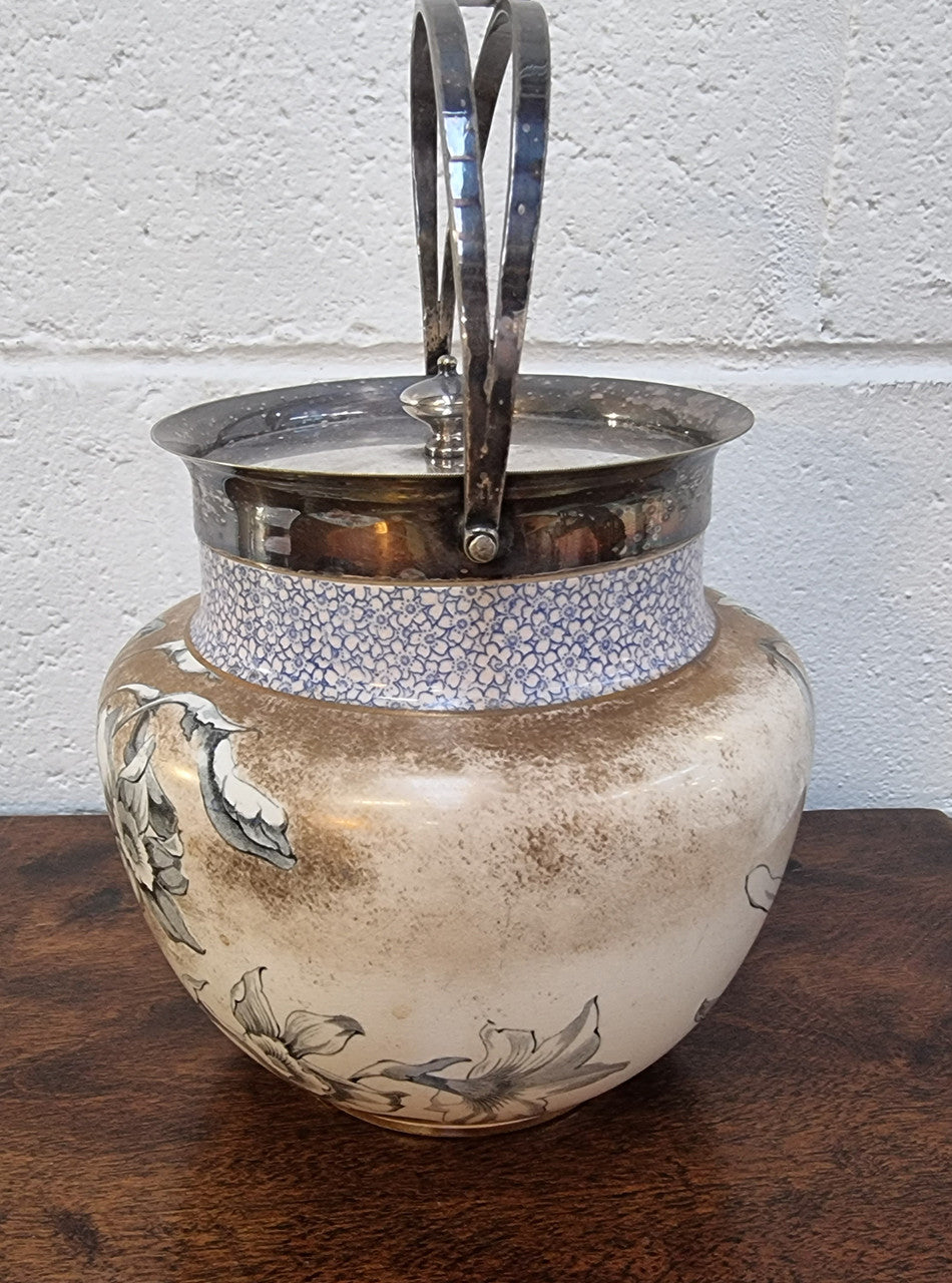 Royal Doulton Biscuit Barrel with silver plated top, handle and lid. Displaying a Daffodil pattern. In original condition please view photo's as they form part of the description.