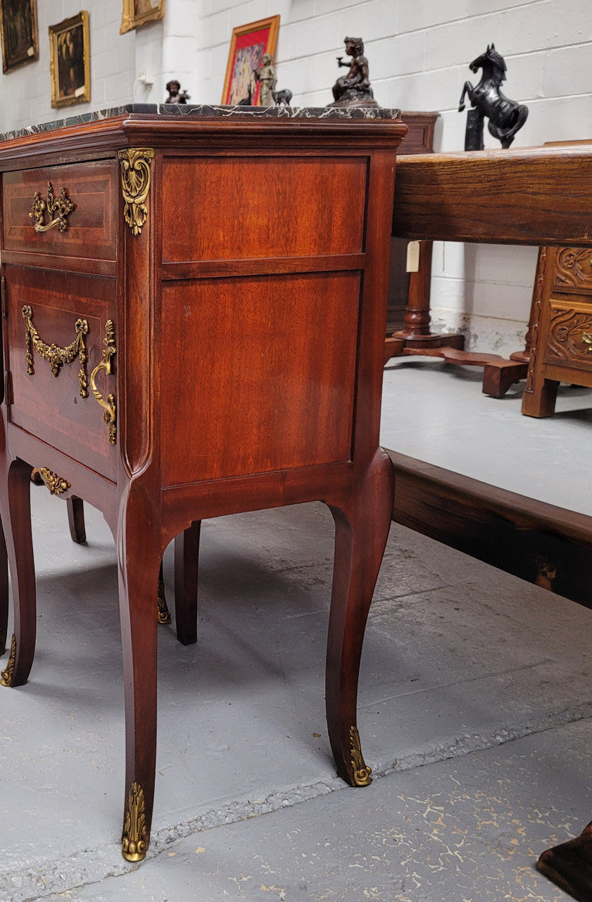 Appealing Louis XV style high quality bedside cabinets with black Portoro marble top and bronze mounts. They have been sourced from France and are in good original condition.