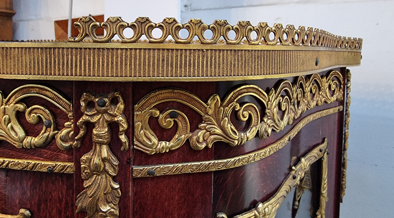 French Mahogany two shelf vitrine with curved glass and brass mounts. It has a lovely frabic interior and two glass shelves. In good original detailed condition.