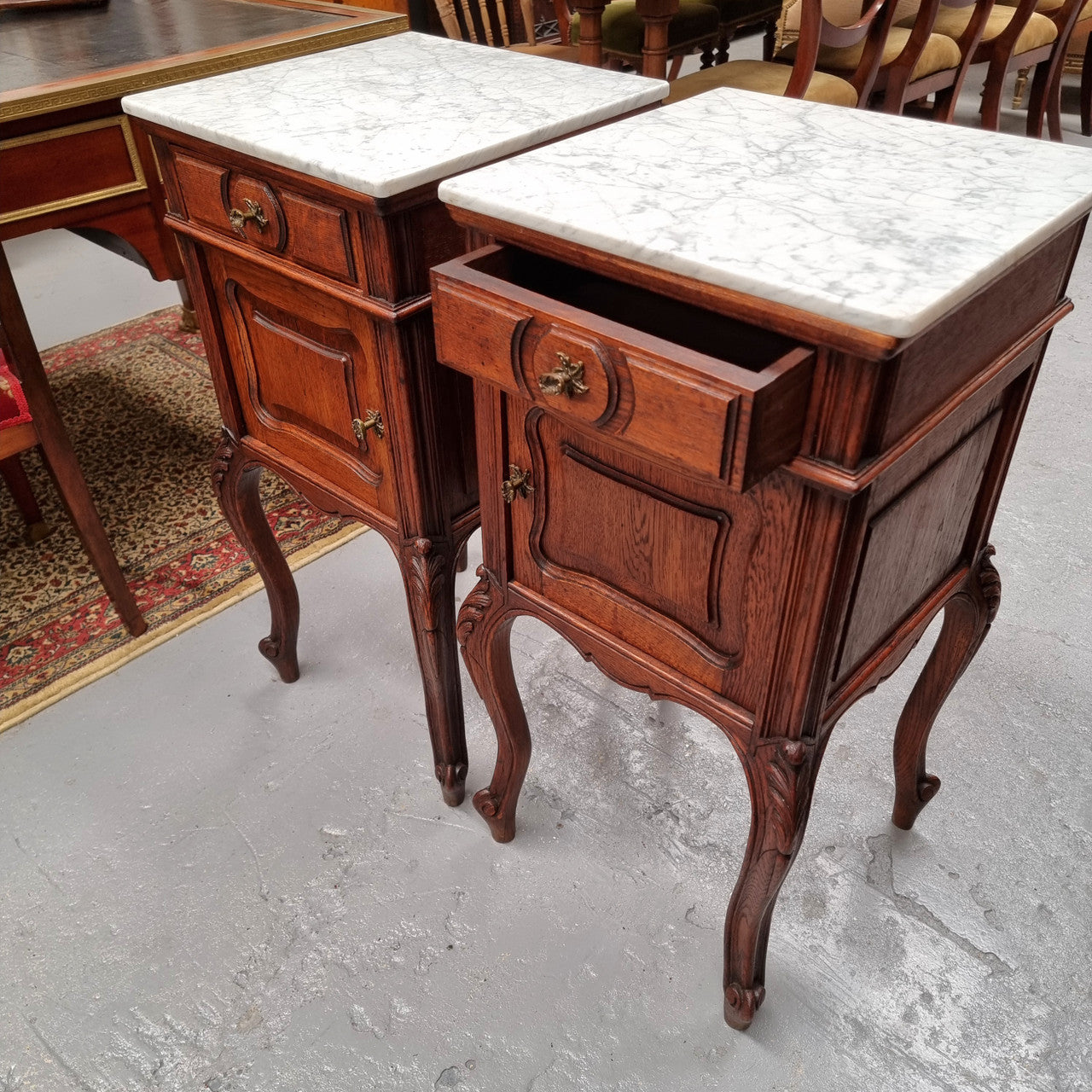 Elegant French Louis XV style pair of carved Oak white marble top bedsides. They are in good original condition and they have been detailed to a high standard. They have been sourced from France.