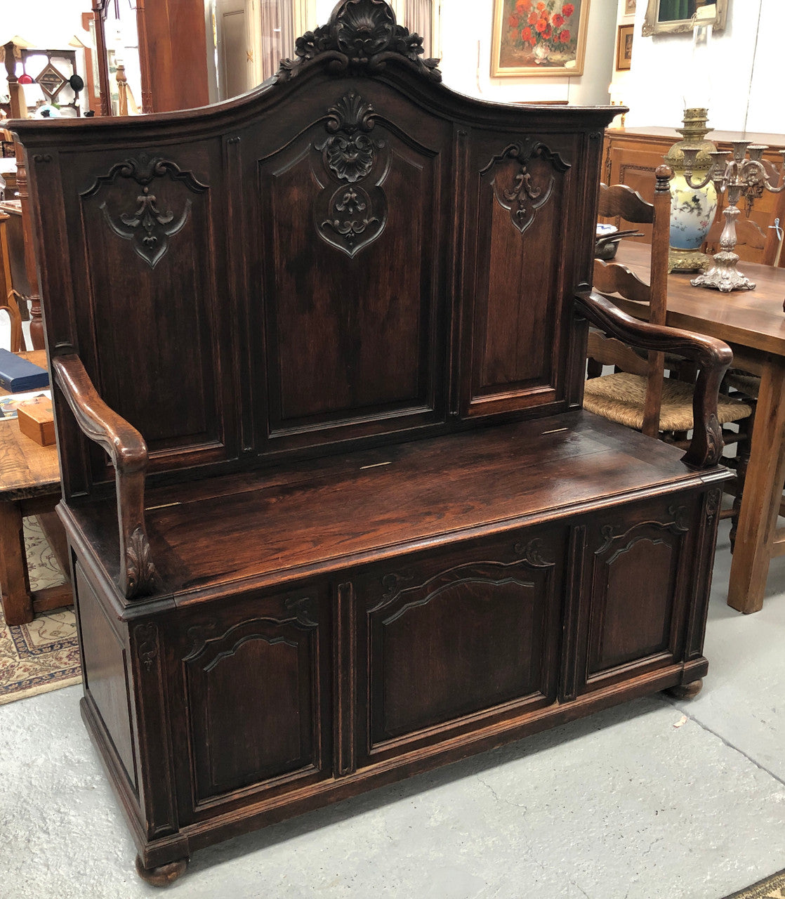 Beautifully carved French Oak hall seat with a lift up lid and storage space inside. In good original detailed condition.