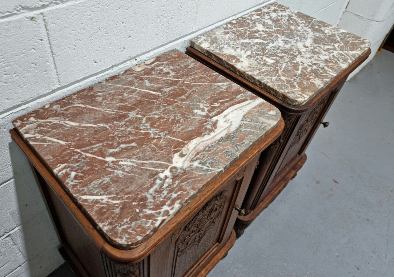 Lovely pair of French oak bedside cabinets with nicely carved details and marble tops. In good original detailed condition.