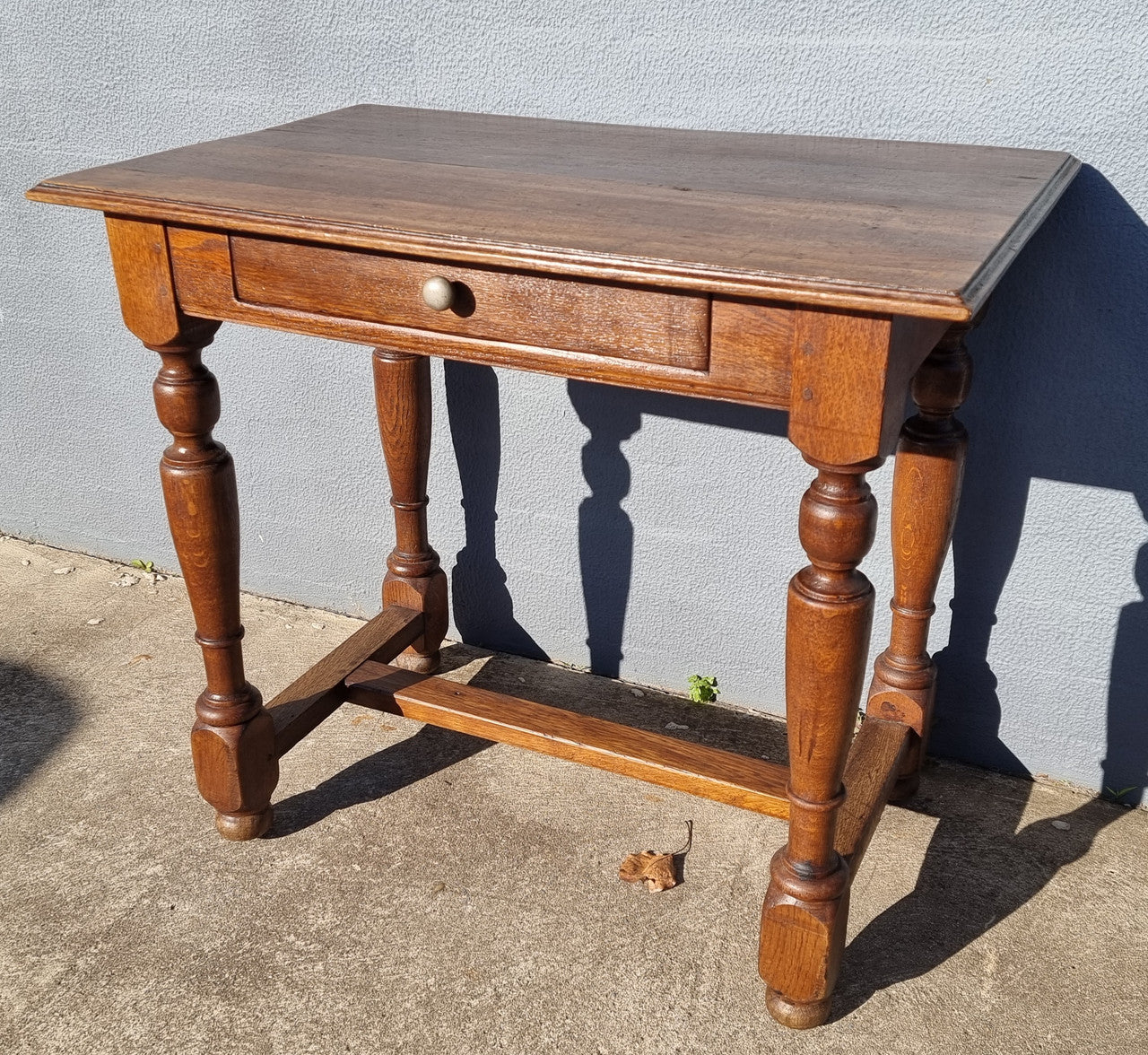 Rustic French Oak side table or desk with single drawer and turned legs. In good original detailed condition.