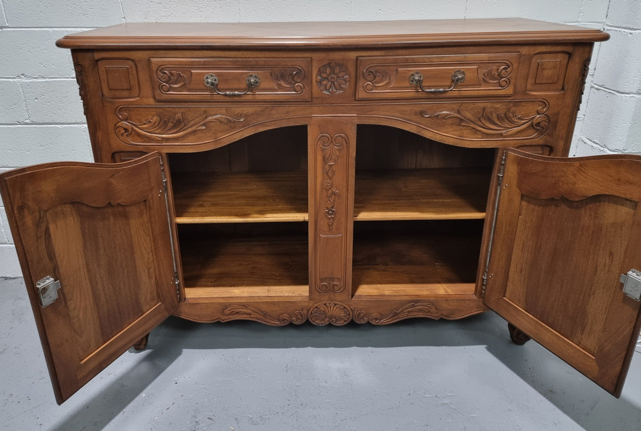 French Walnut two door buffet with parquetry top. It has two drawers and an adjustable shelf. In good original detailed condition and it has been sourced from France.