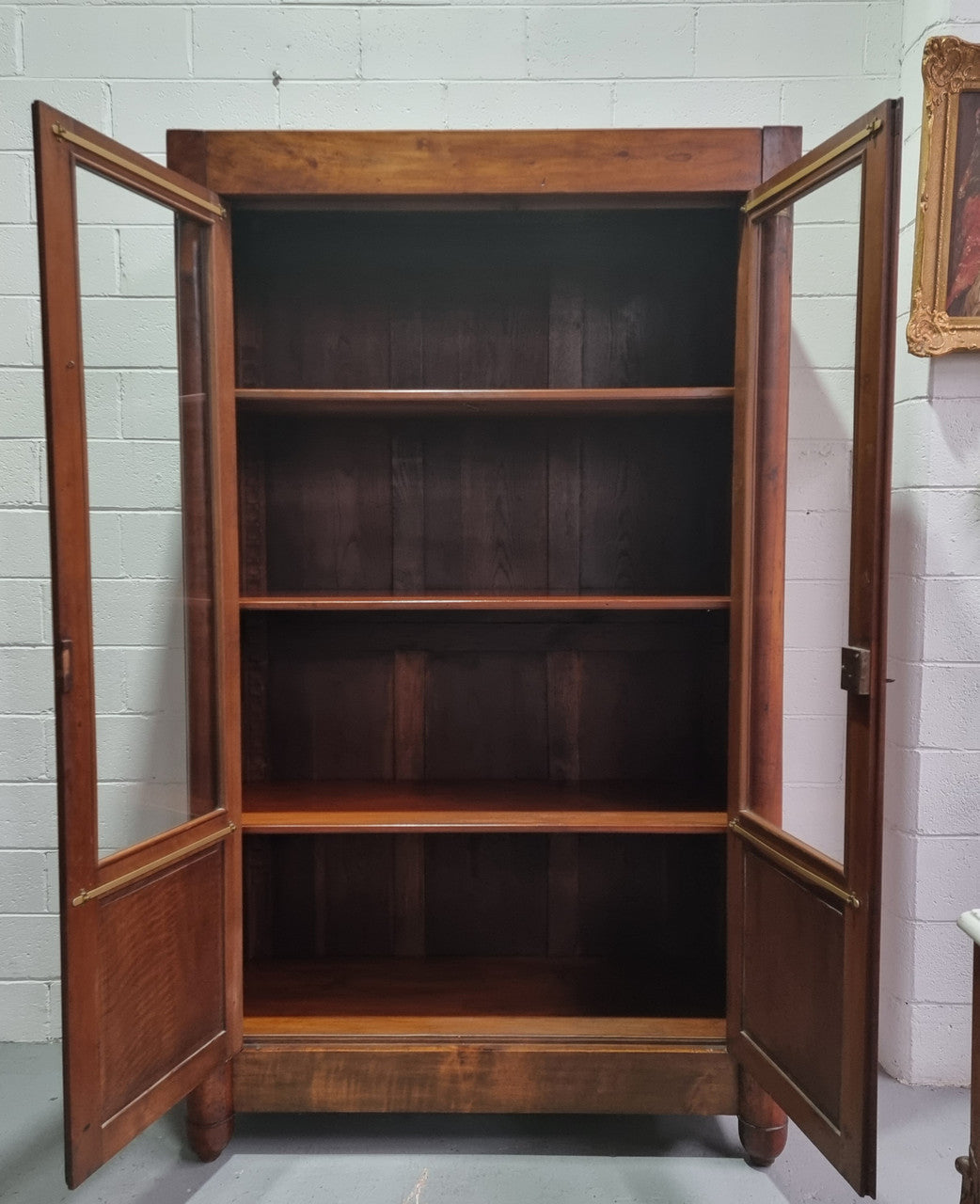 Grand French Mahogany Empire two door bookcase. It has beautiful glass doors and has three fully adjustable shelves. It has been sourced from France and is in good original detailed condition.