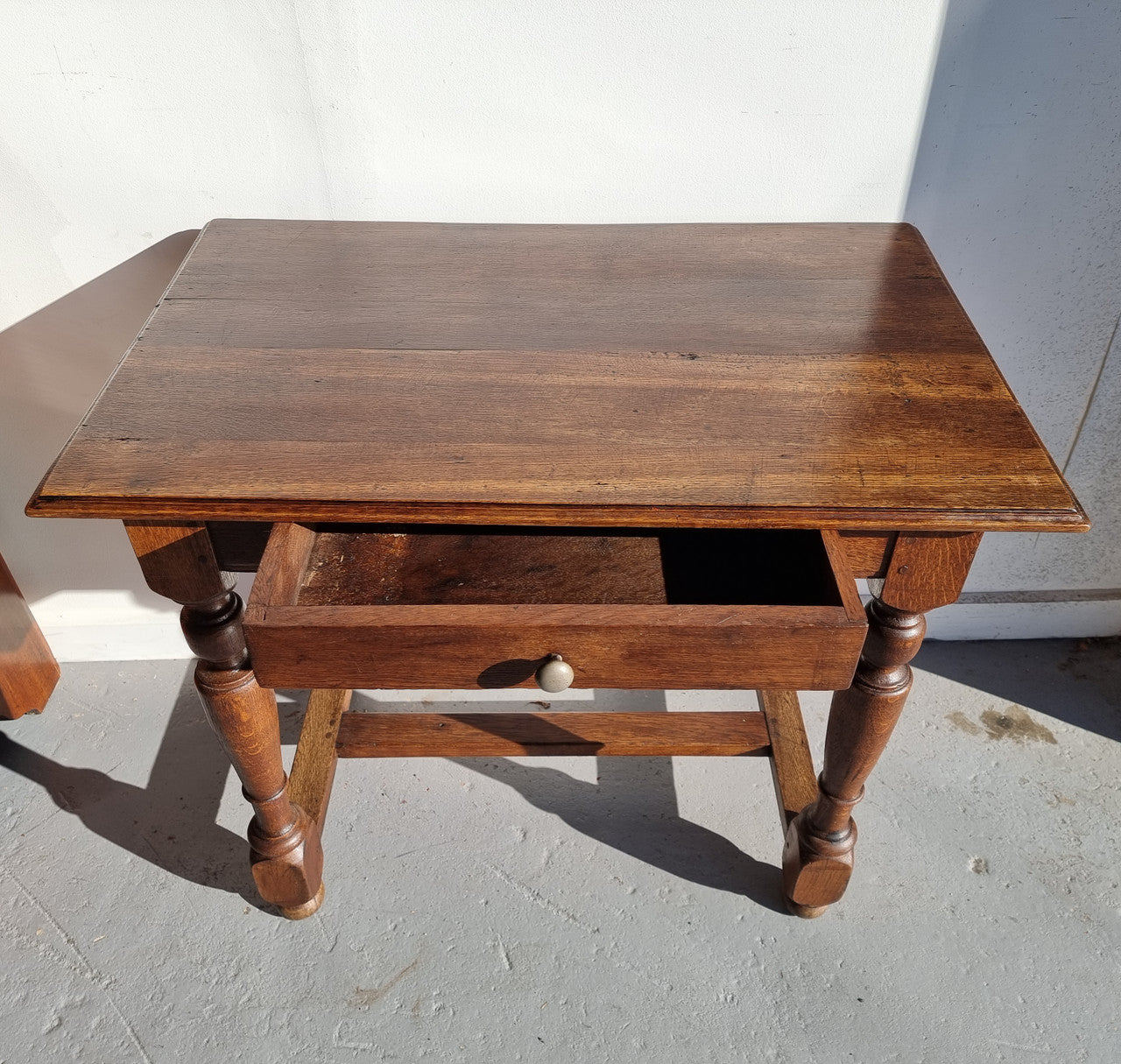 Rustic French Oak side table or desk with single drawer and turned legs. In good original detailed condition.