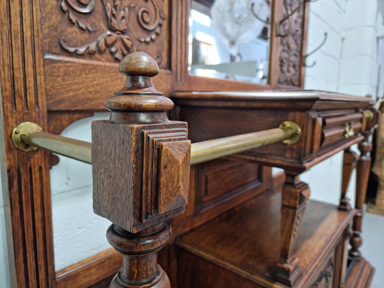 Grand Henry 2nd Style French Oak hall stand with 12 hanging hooks. Also has one cupboard and drawer for storage along with a mirror and two areas either side for umbrellas and walking sticks. In good original detailed condition.