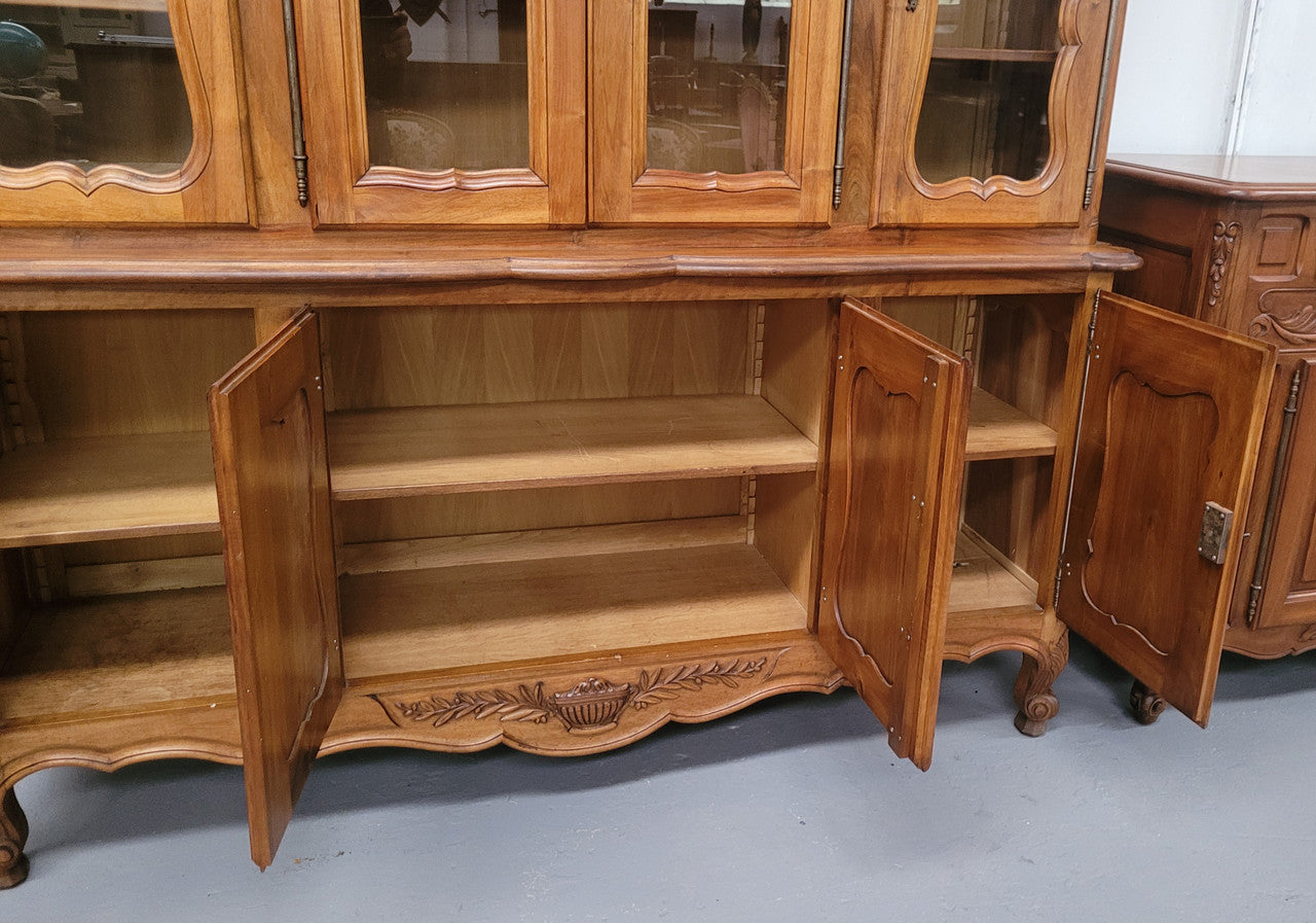 Magnificent French Walnut two-body four door display cabinet. Heaps of storage space with four glass doors at the top with shelves and four solid doors below also with shelving. It has been sourced from France and comes with a key for each door and all are lockable. In good original detailed condition.