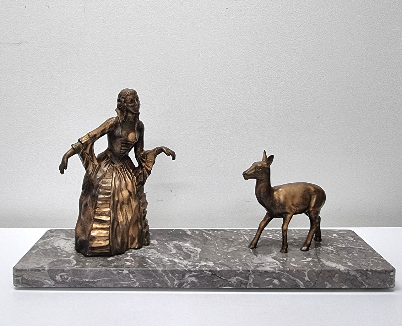 Art Deco gilt metal lady and deer statue on a lovely grey marble base. It has been sourced from France and is in good original condition. The marble does have some minor chips and wear due to age, please view photos as they help form part of the description. Please contact us if you would like additional photos.