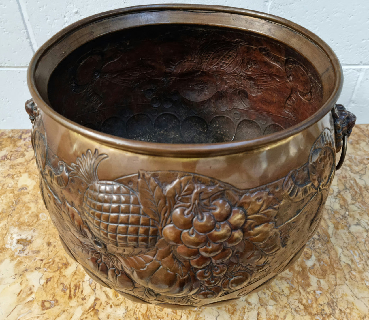 Antique large brass bronze coloured embossed Jardinière/planter with lovely details and lion heads for handles. It is in good original condition.