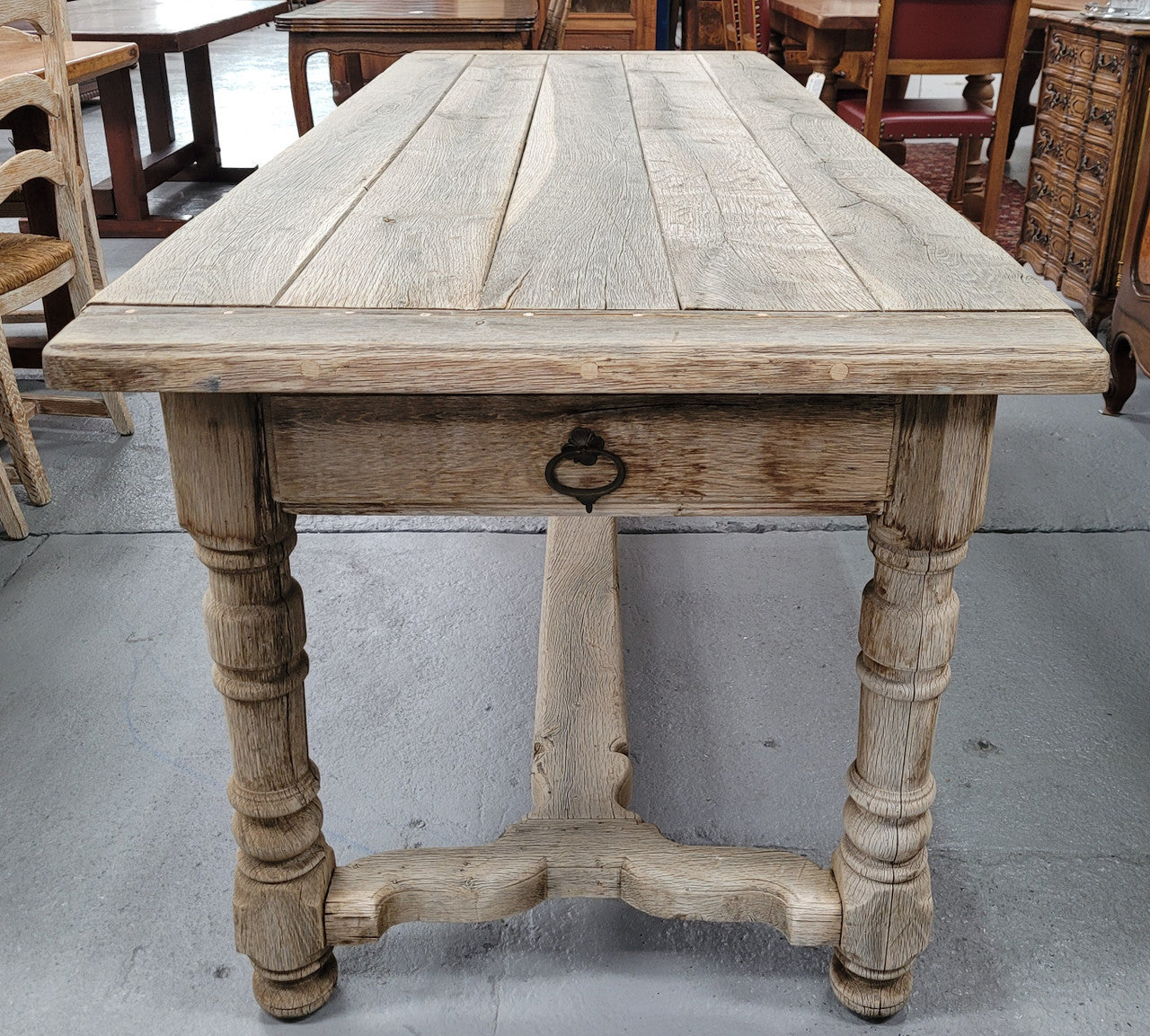 French stripped Oak pedestal stretcher base Farmhouse table with two drawers on either side of table. Features raw wood that could be used as is for a distressed look, or finished and waxed for a more refined look.